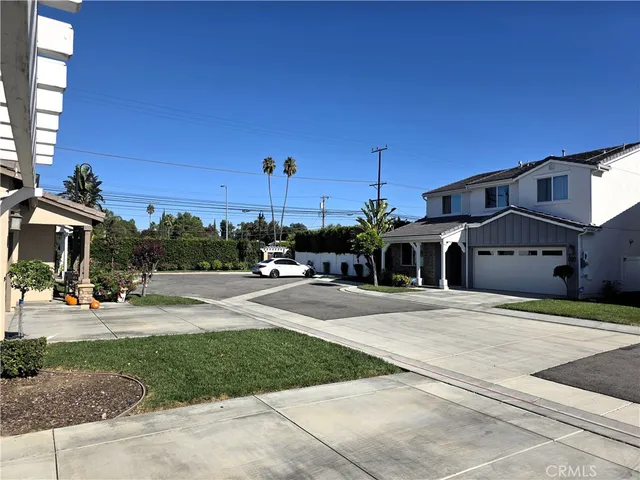 a front view of a house with a yard and potted plants