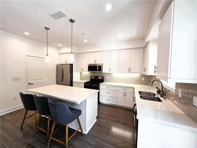 a kitchen that has a lot of cabinets in it with appliances and cabinets
