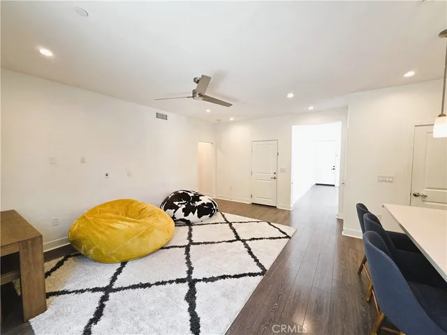 a living room with a dining table chairs and a chandelier