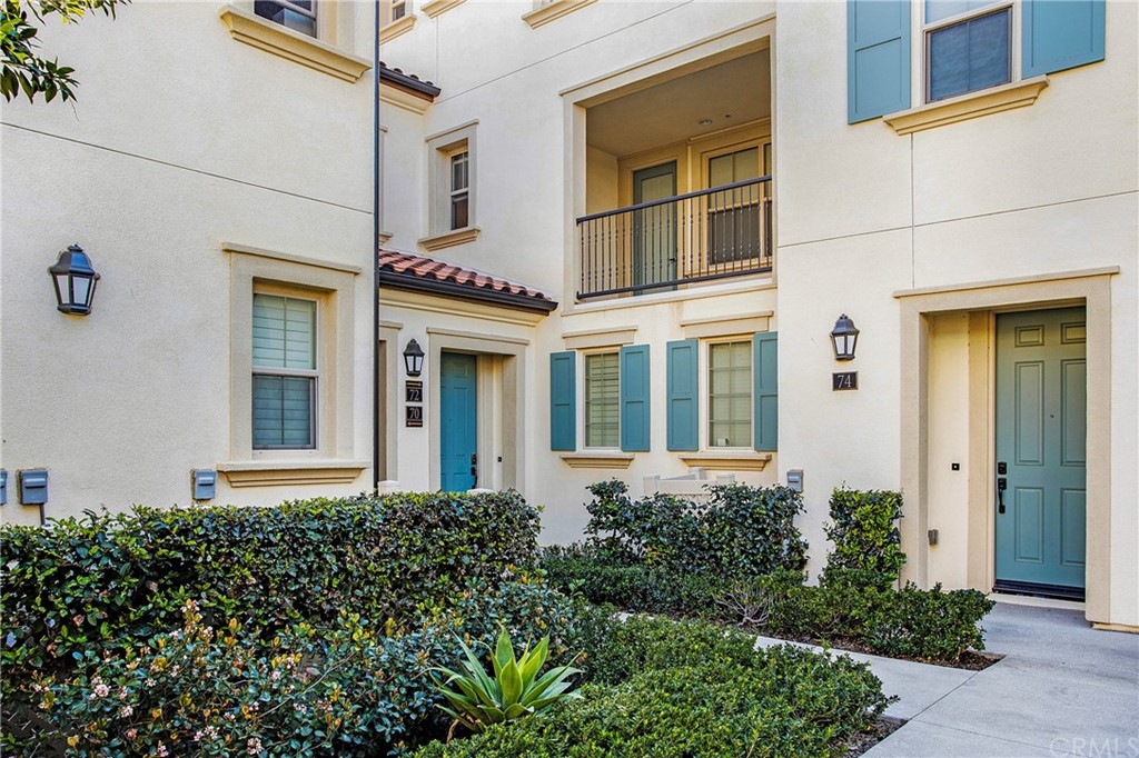 front view of a brick house with a large windows and a potted plant
