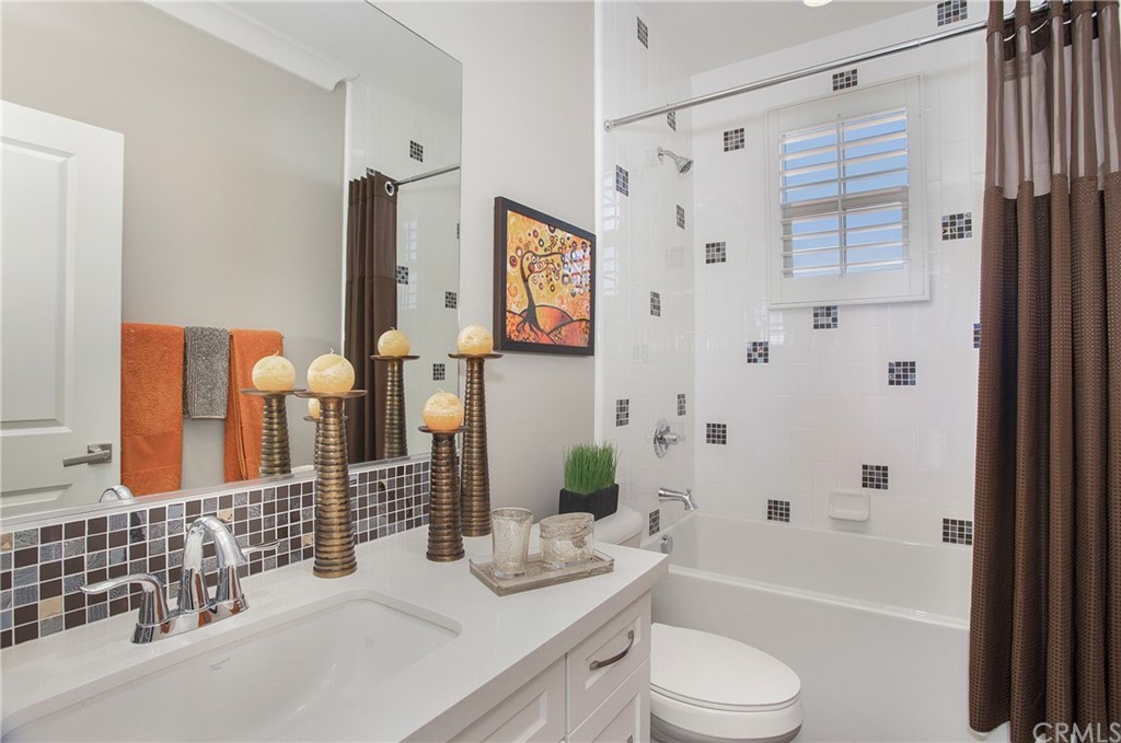 72 Capricorn Irvine, CA 92618 - Photo 19 of 24 a bathroom with a granite countertop sink toilet a mirror a bathtub and shower