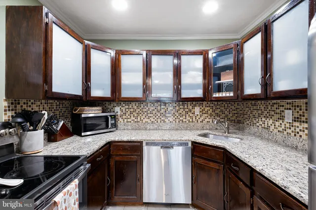 a kitchen with stainless steel appliances granite countertop a sink stove and cabinets