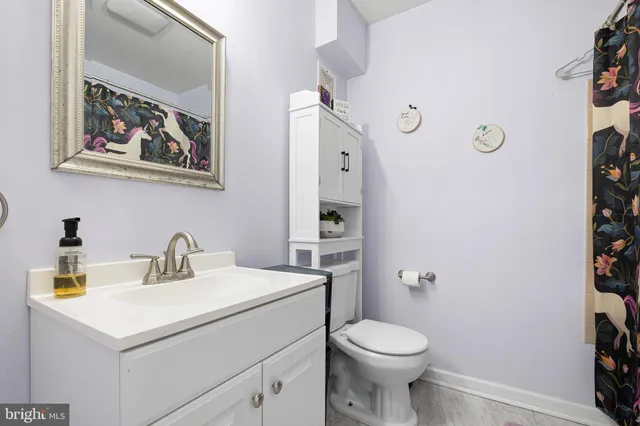 a bathroom with a toilet sink and mirror