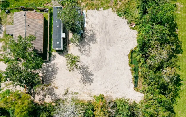 an aerial view of a house with a yard and large trees