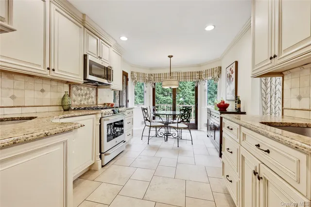 a kitchen with stainless steel appliances granite countertop a stove a sink and a microwave