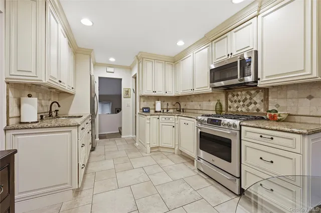 a kitchen with stainless steel appliances granite countertop a refrigerator and a stove top oven