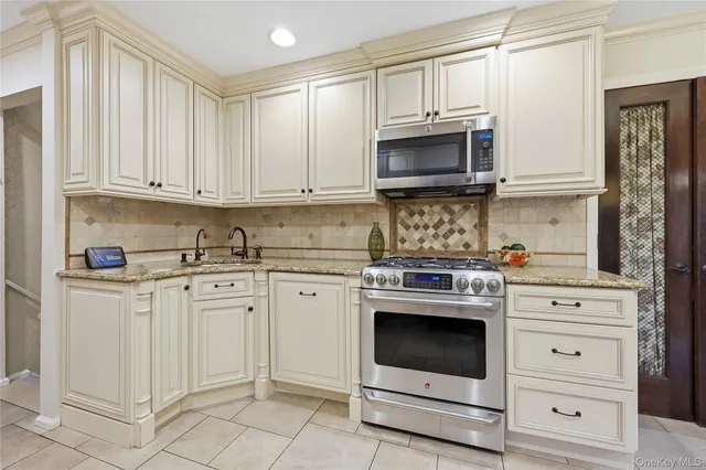 a kitchen with stainless steel appliances granite countertop a stove a sink and a refrigerator