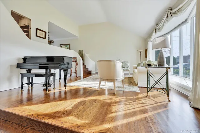 a living room with furniture a wooden floor and next to a window
