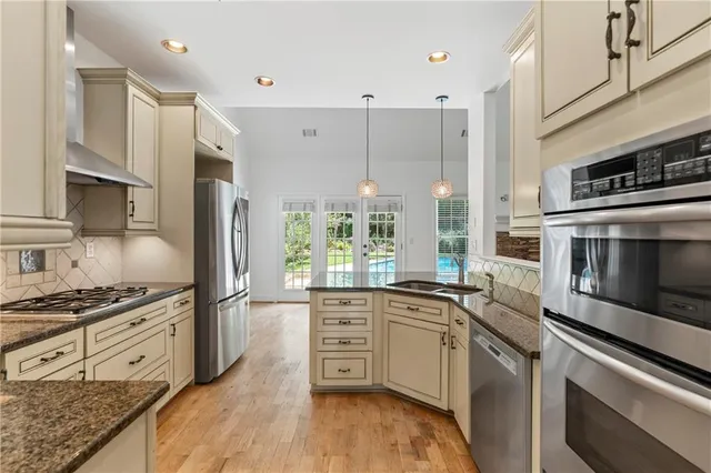 a kitchen with stainless steel appliances a stove sink and cabinets