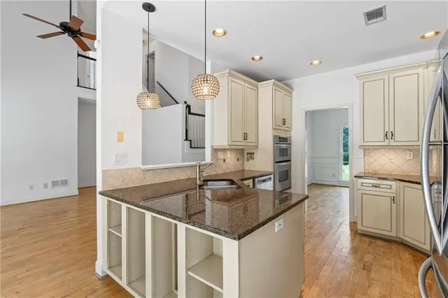 a kitchen with stainless steel appliances granite countertop a sink a refrigerator and a stove