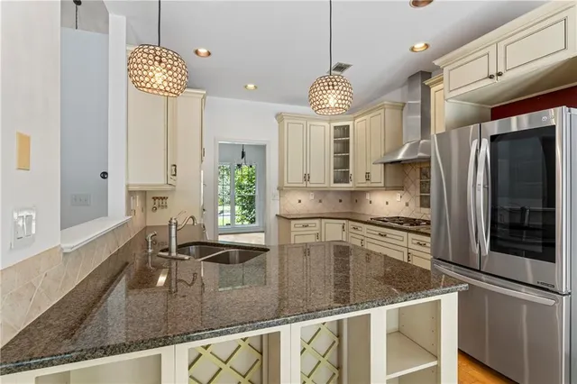 a kitchen with stainless steel appliances granite countertop a sink a stove and a refrigerator