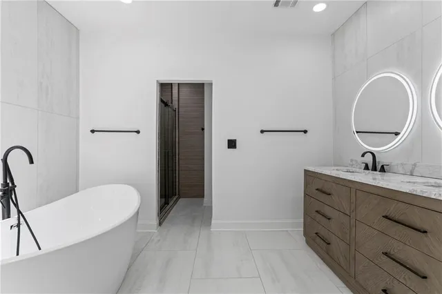 a en suite bathroom with a granite countertop sink and a mirror