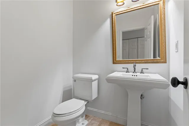 a bathroom with a toilet a sink and mirror