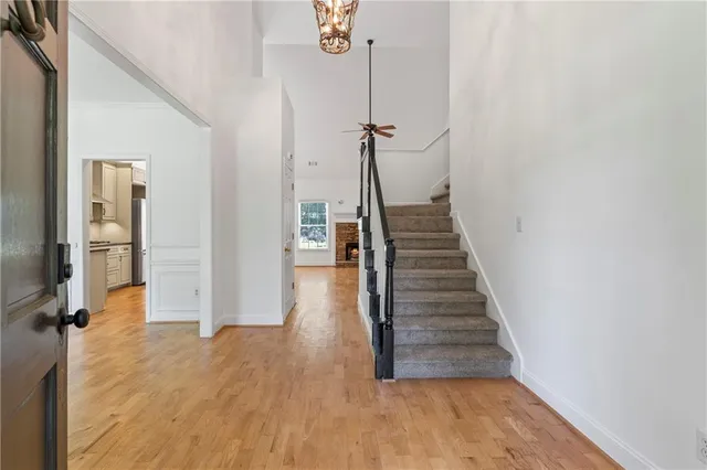 a view of a hallway with wooden floor and staircase