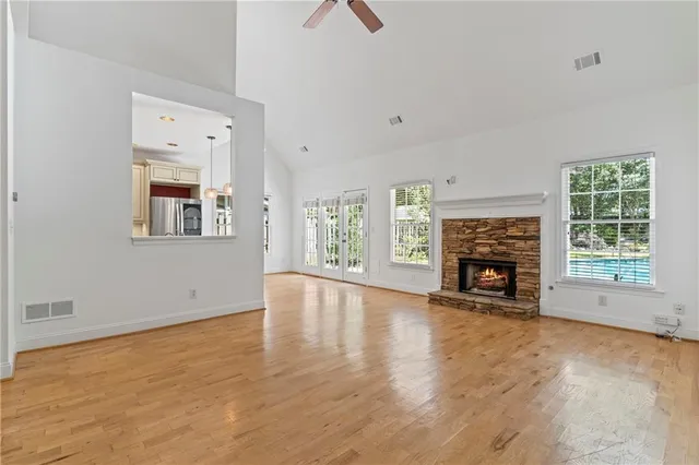 an empty room with fireplace wooden floor and windows