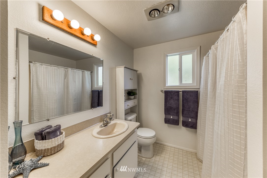 6324 Cady Road, Unit B Everett, WA 98203 - Photo 22 of 22 a bathroom with a toilet a sink and mirror