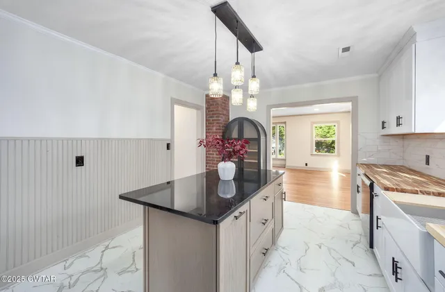 a kitchen that has a lot of cabinets and stainless steel appliances