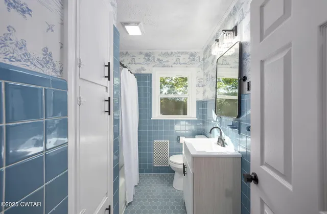 a bathroom with a sink mirror and window
