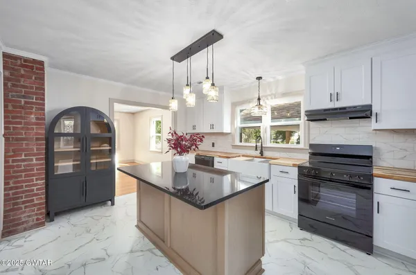 a kitchen with stainless steel appliances granite countertop a sink and a stove