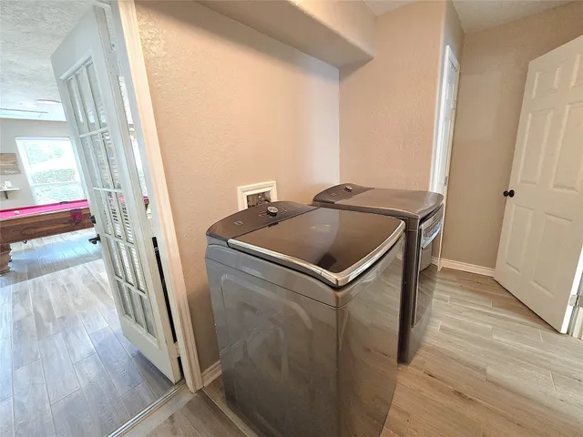 a utility room with wooden floor washer and dryer