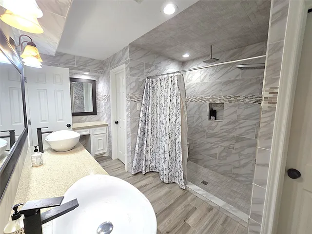 a bathroom with a double vanity sink toilet and shower