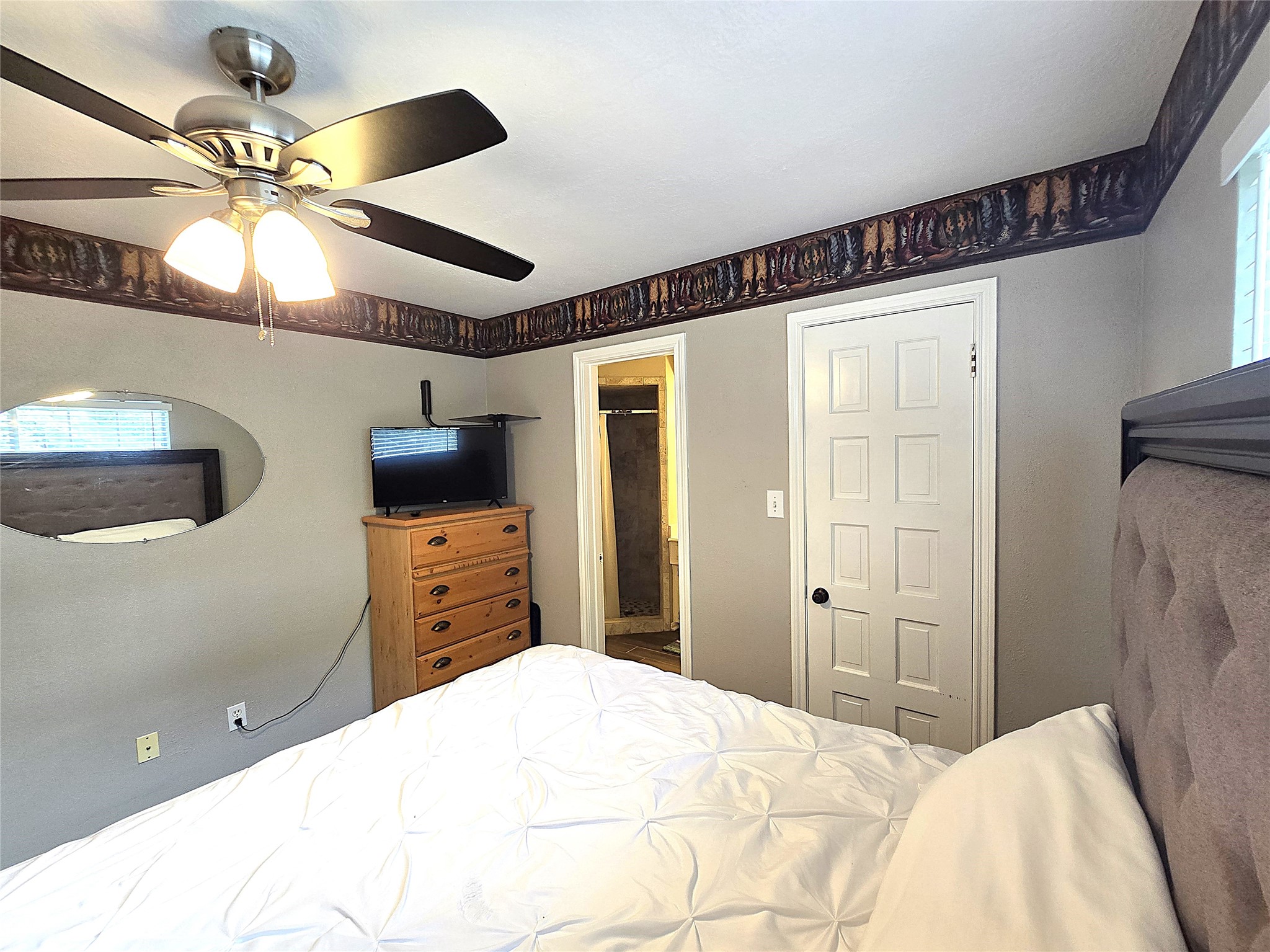 560 Brandon Road Conroe, TX 77302 - Photo 19 of 45 a bedroom with a bed and a chandelier