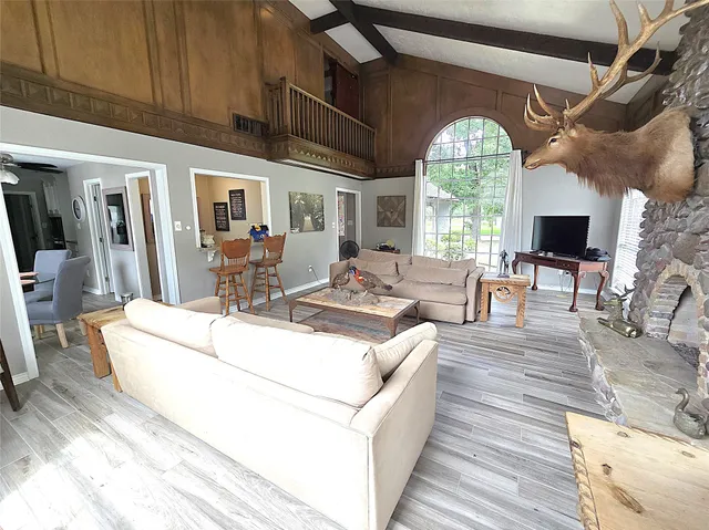 a living room with furniture fireplace and a large window