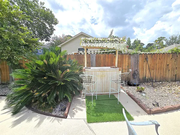 a view of a patio with table and chairs with wooden floor and fence