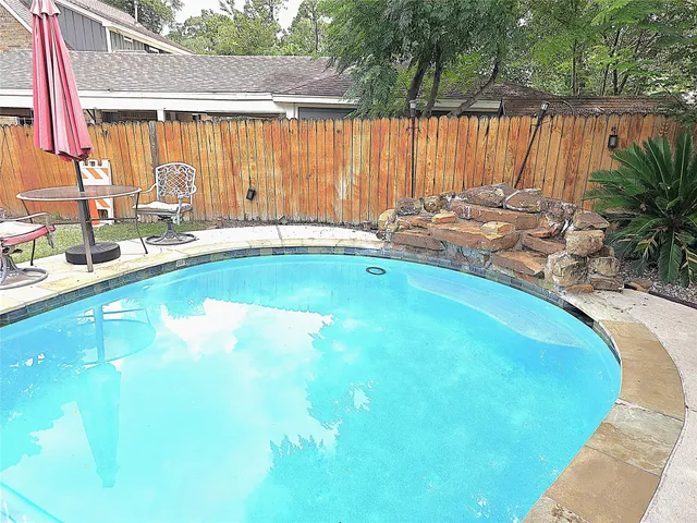 a view of a house with pool and sitting area