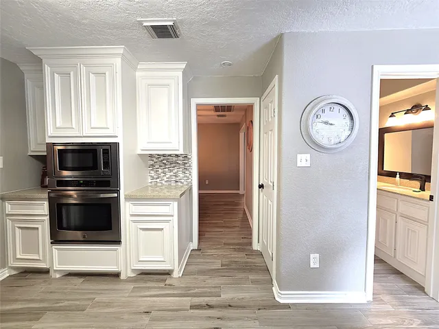 a view of kitchen with wooden floor electronic appliances and furniture