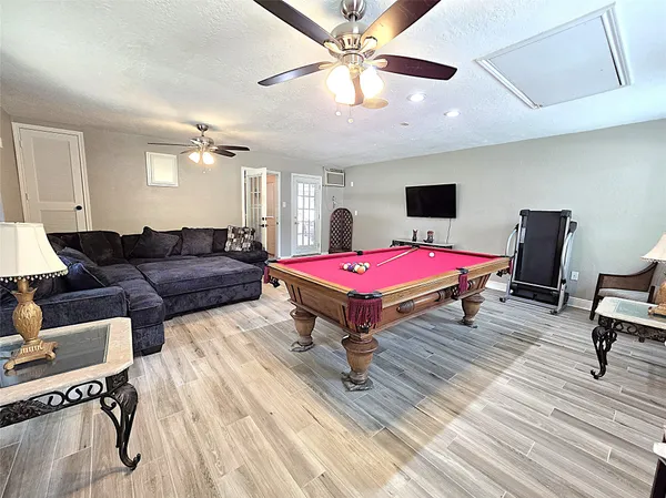 a living room with furniture a flat screen tv and a chandelier