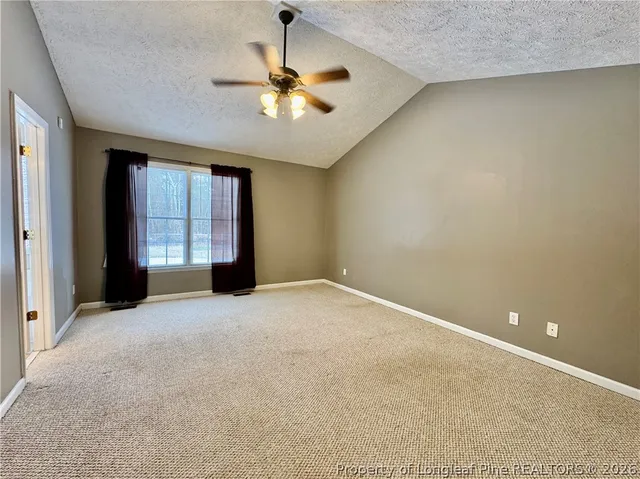 a view of an empty room with a chandelier fan
