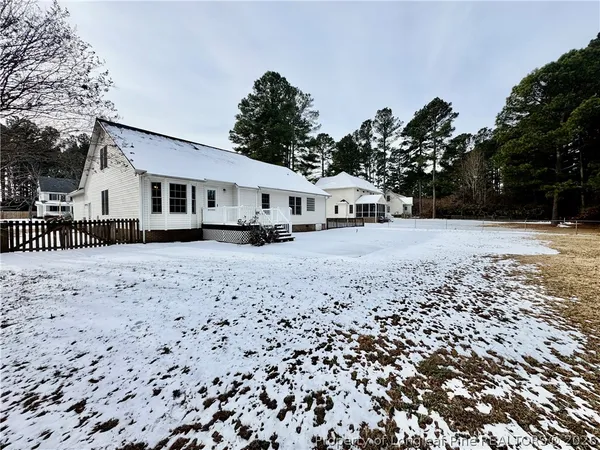 a front view of a house with a yard covered in snow