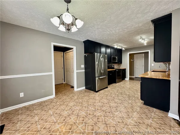 a view of an empty room with wooden floor and a fireplace