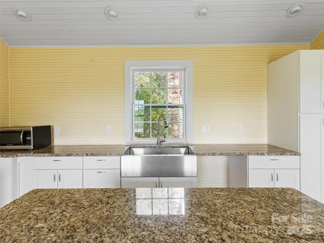 a kitchen with a sink a stove and cabinets