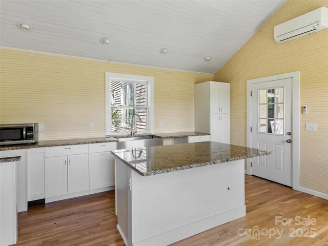 a kitchen with stainless steel appliances granite countertop a sink and dishwasher with wooden floor