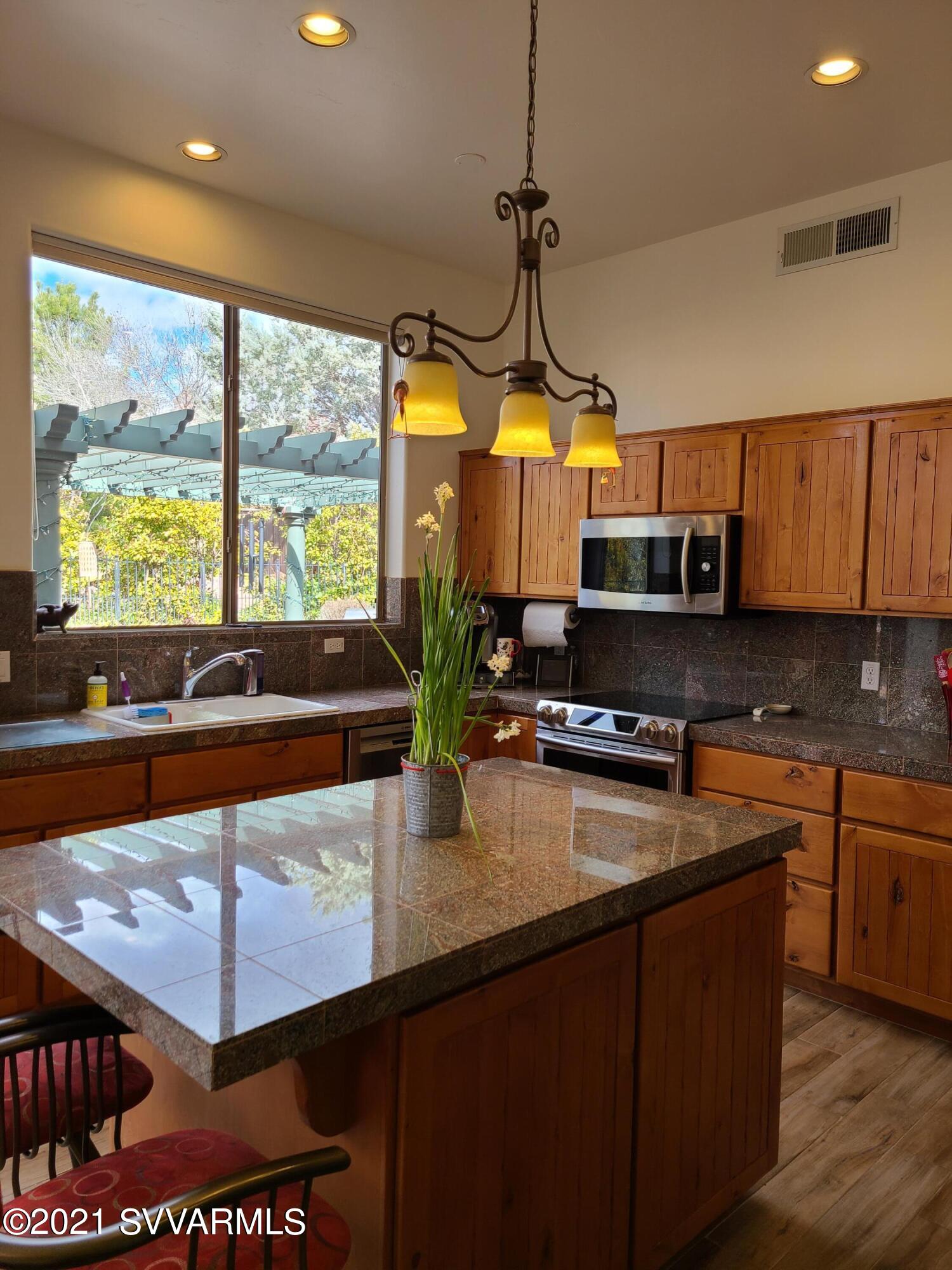 610 Rodeo Road Sedona, AZ 86336 - Photo 4 of 20 a kitchen with stainless steel appliances granite countertop a sink a stove and a wooden floors