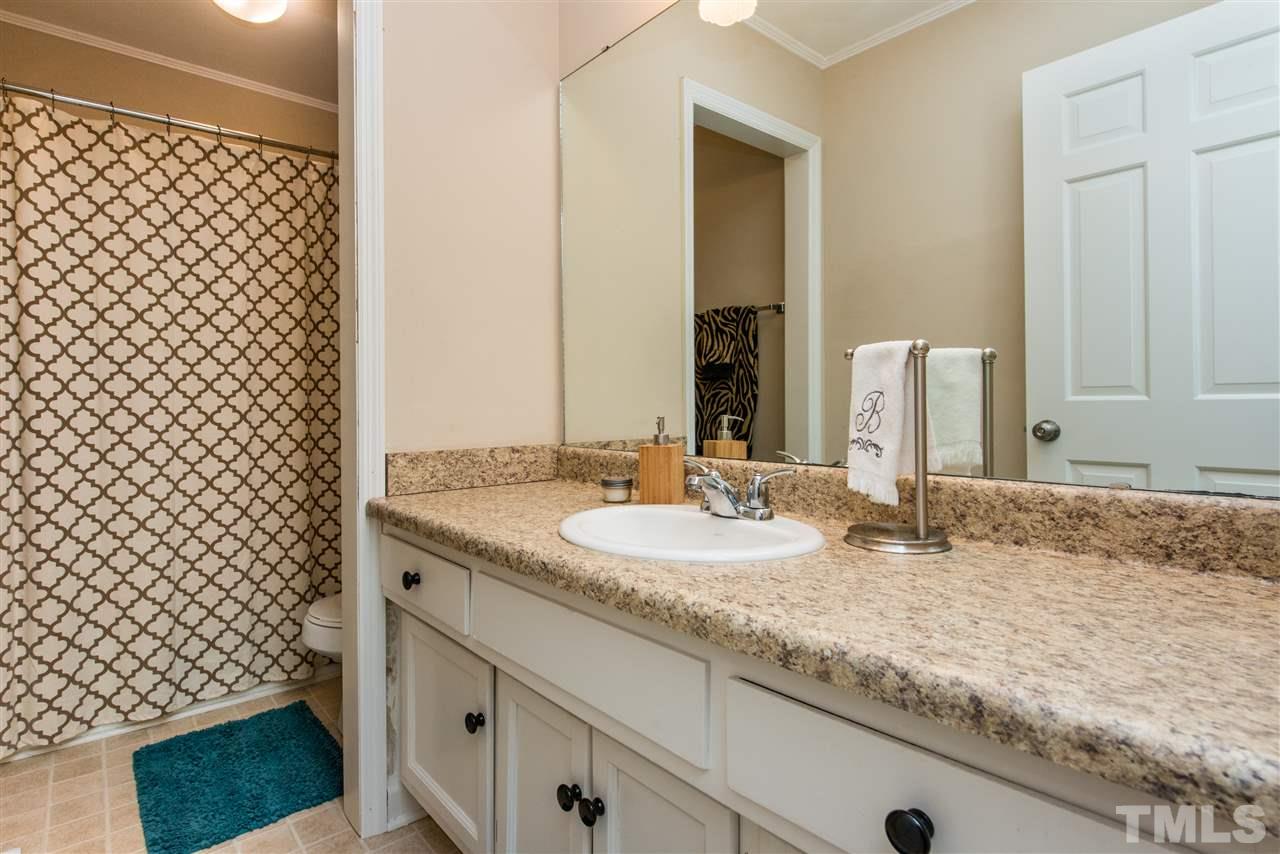 3512 Peach Haven Court Raleigh, NC 27607 - Photo 20 of 25 a bathroom with a granite countertop sink and a mirror