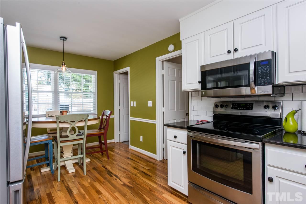 3512 Peach Haven Court Raleigh, NC 27607 - Photo 5 of 25 a kitchen with a stove a microwave and wooden cabinets