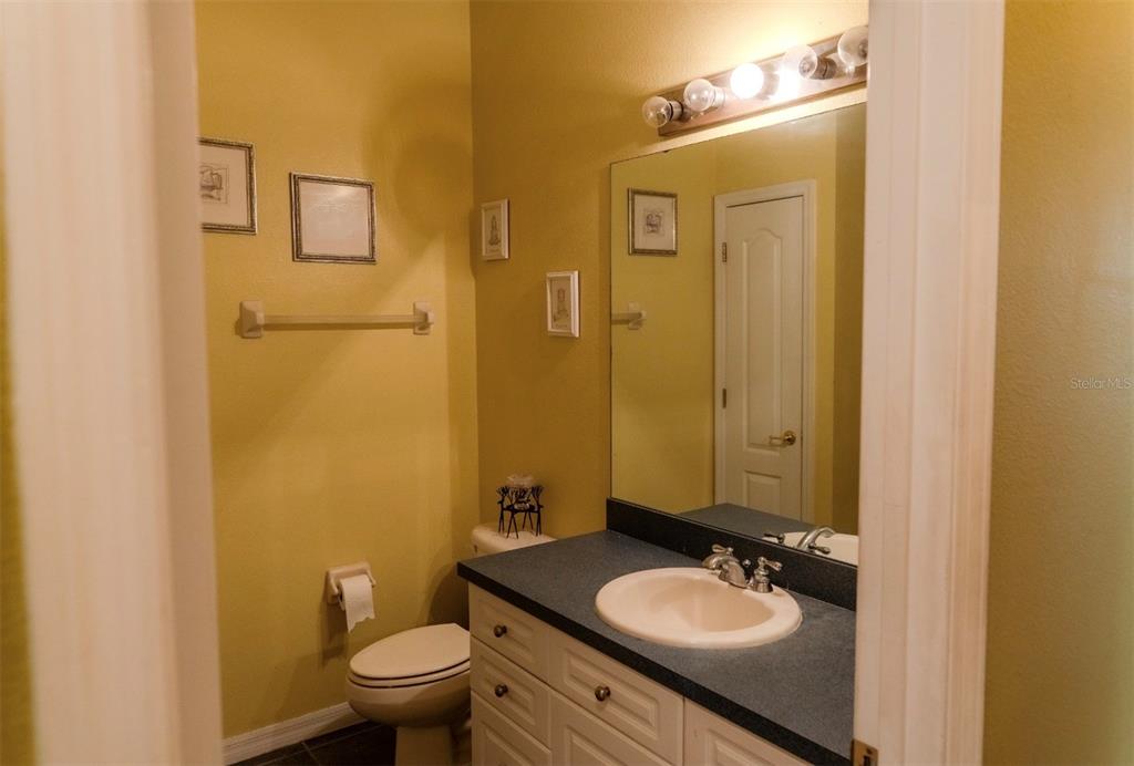 6673 Duncaster Street Windermere, FL 34786 - Photo 13 of 25 a bathroom with a granite countertop sink toilet and mirror