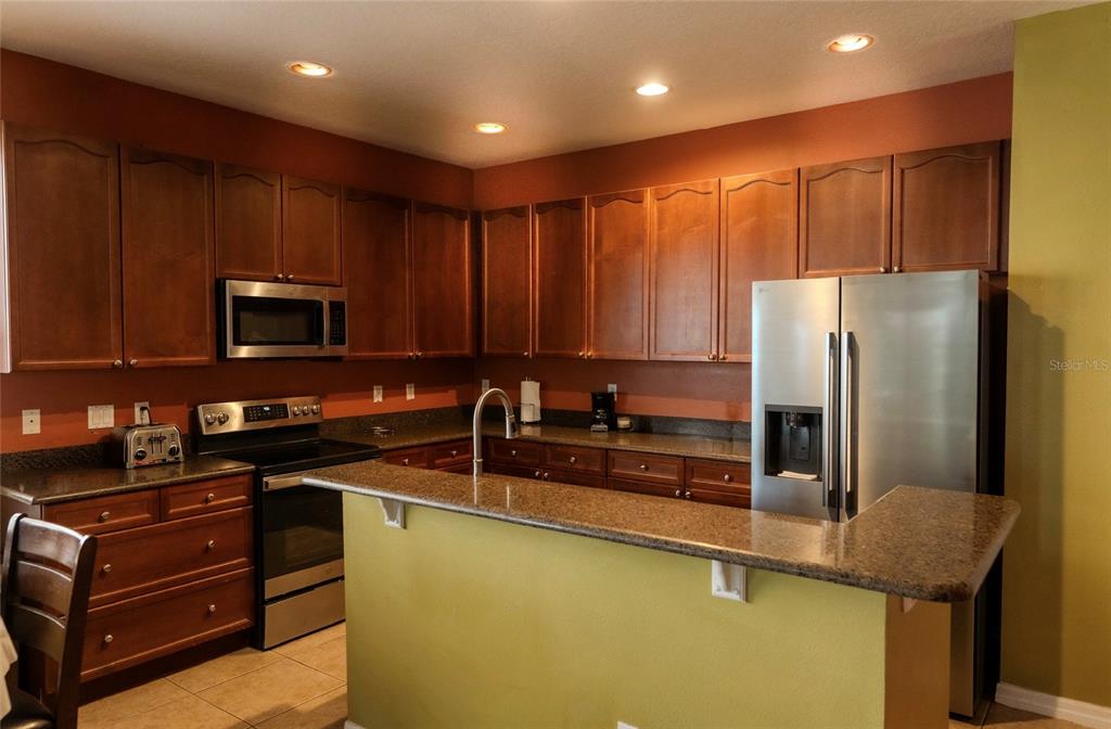 6673 Duncaster Street Windermere, FL 34786 - Photo 6 of 25 a kitchen with stainless steel appliances granite countertop a refrigerator stove a sink and dishwasher
