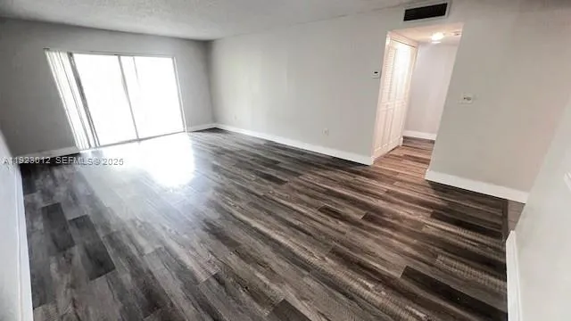 a view of an empty room and wooden floor