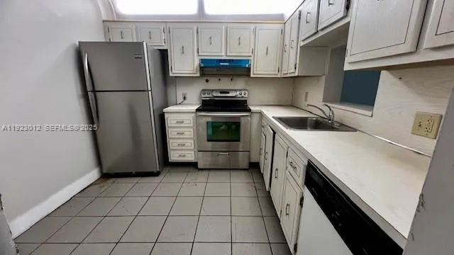 a kitchen with a refrigerator sink and cabinets