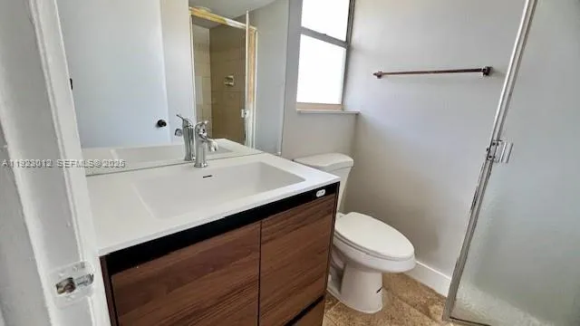 a bathroom with a sink a toilet a mirror and shower