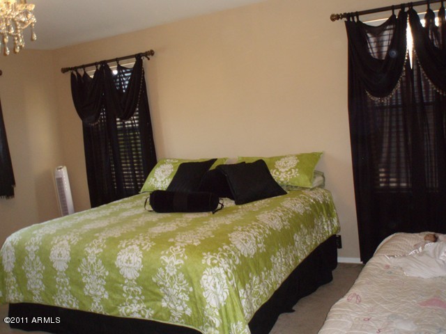 2933 East Blue Sage Road Gilbert, AZ 85297 - Photo 13 of 18 a bed sitting in a bedroom and wooden floor