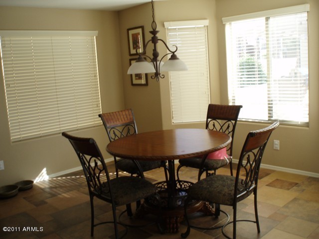 2933 East Blue Sage Road Gilbert, AZ 85297 - Photo 8 of 18 a view of a dining room with furniture and wooden floor