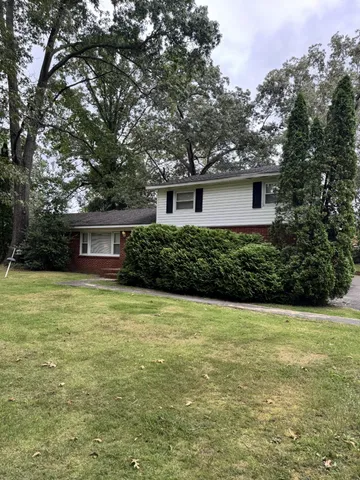 a front view of a house with yard and green space