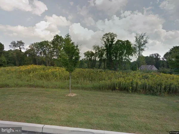 a view of a field with wooden fence