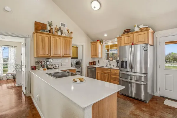a kitchen that has a kitchen island wooden cabinets and stainless steel appliances
