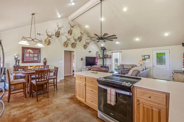 a kitchen that has a stove a table and chairs in it